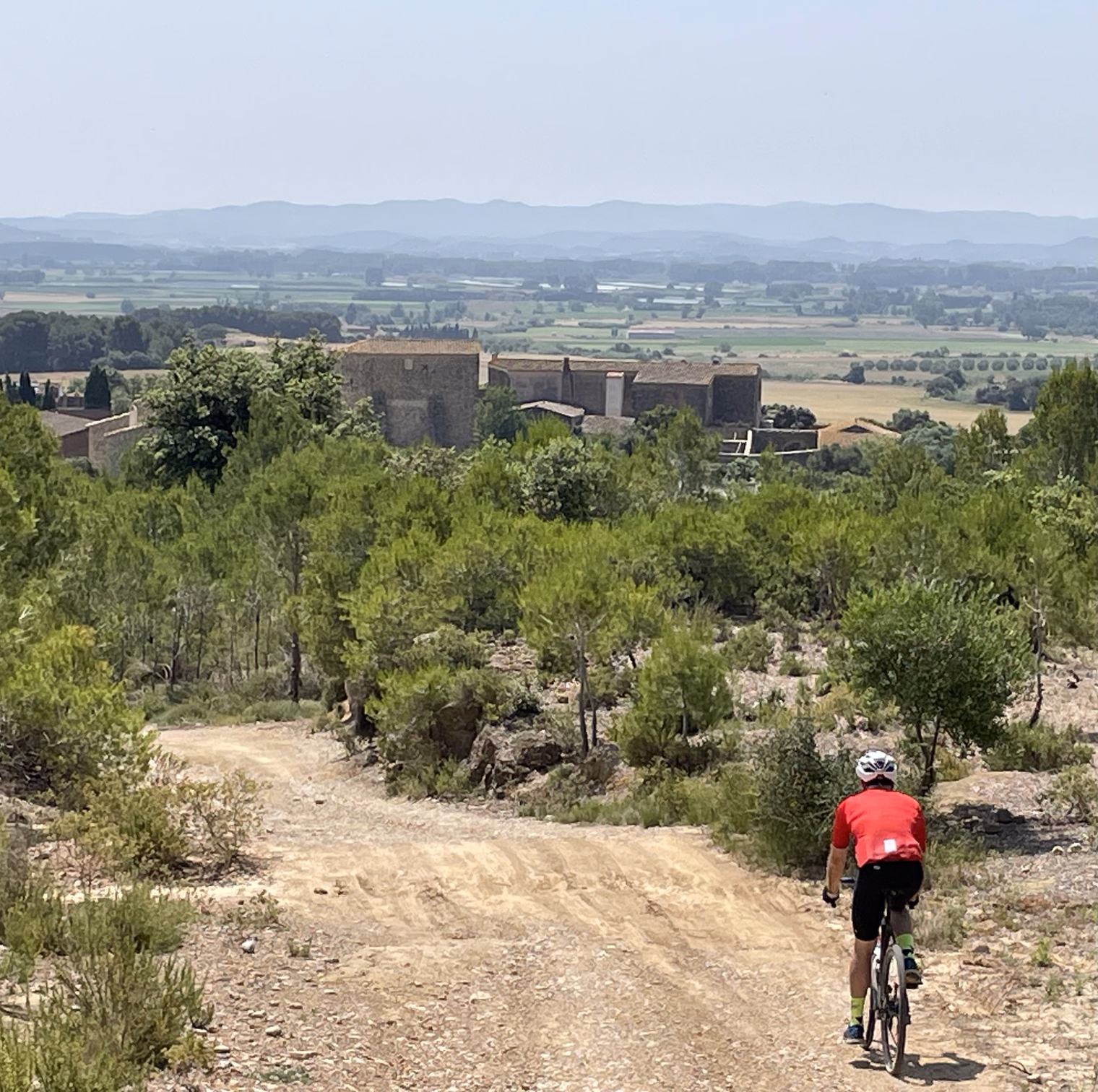 hunter biking down dirt road towards old fortress