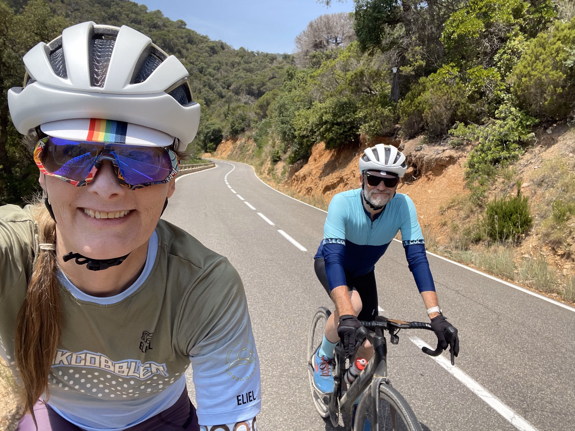 tracey & hunter biking up a coastal road
