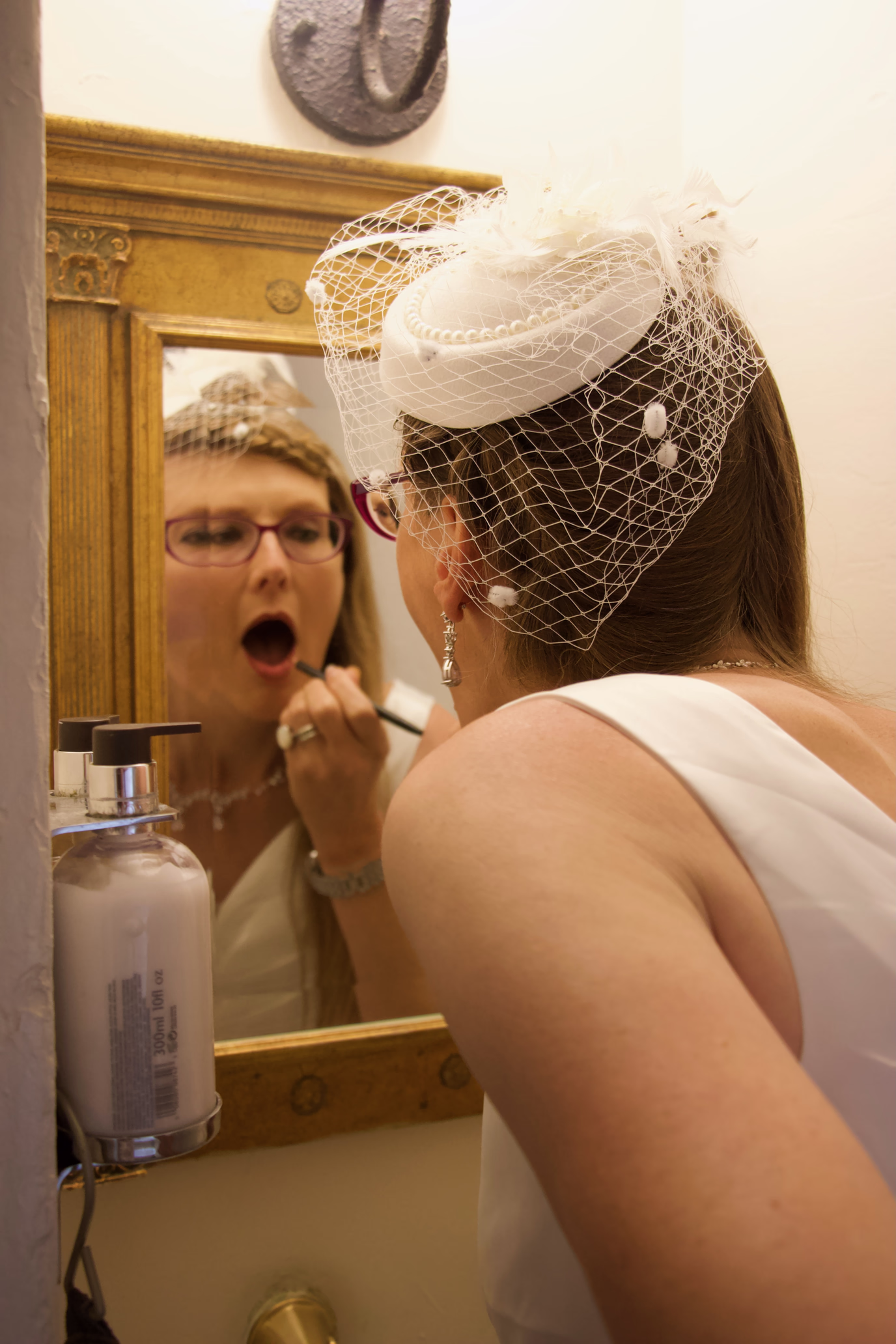 bride doing makeup in mirror