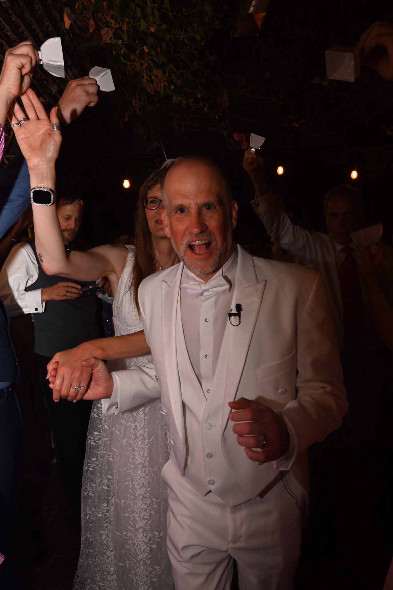 wedding couple running through guests with cowbells